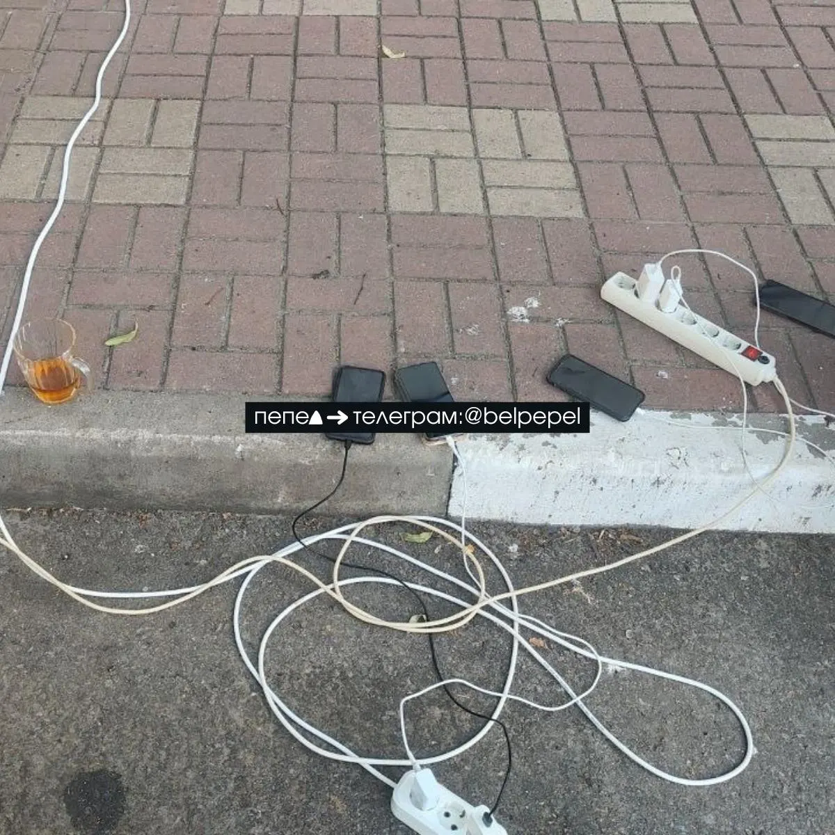 В Белгороде из-за блэкаута люди вынесли зарядные и подключают телефоны к бензиновым генераторам на улицах города.